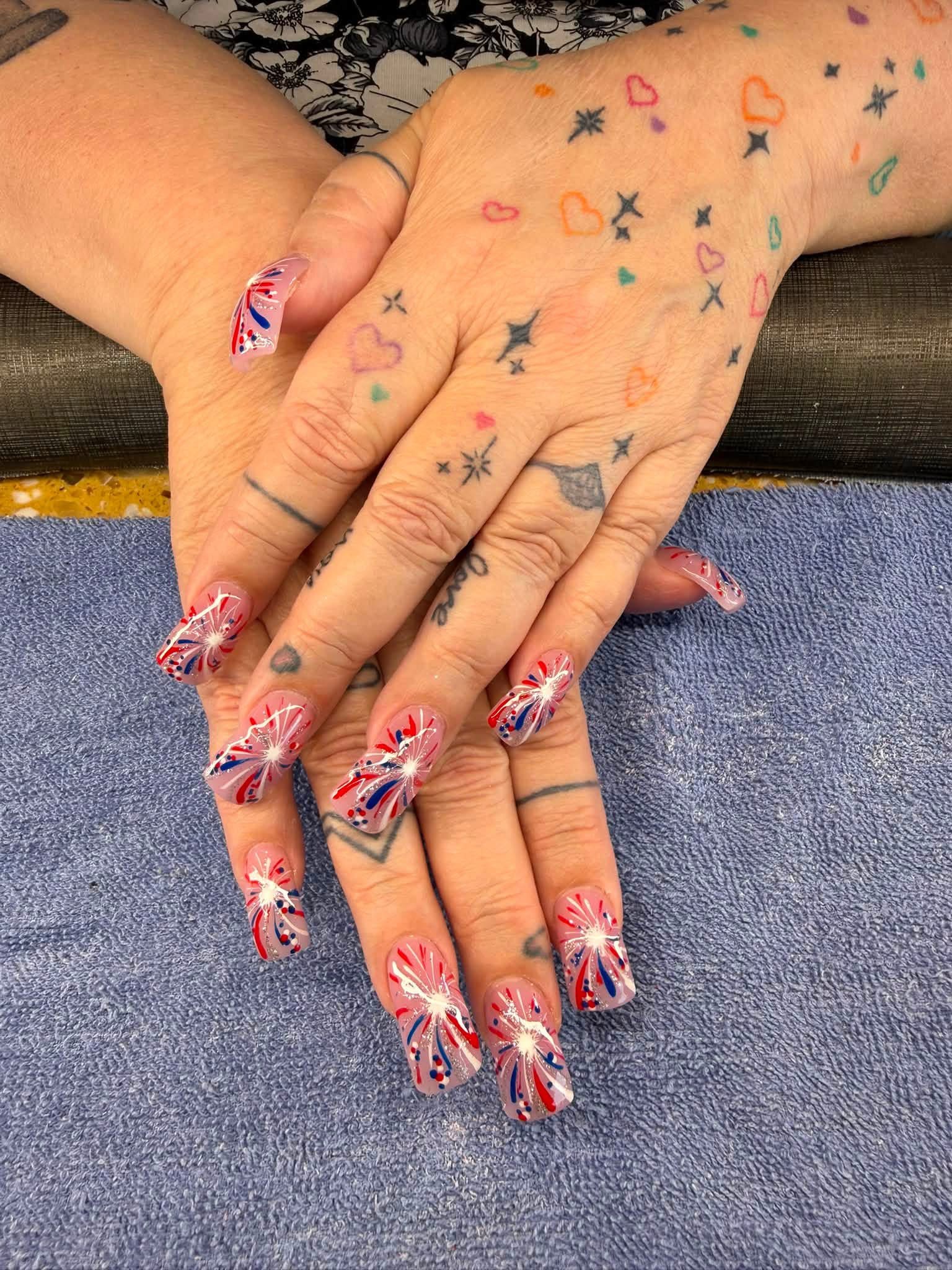 Nail technician detailing nail art with an electric file